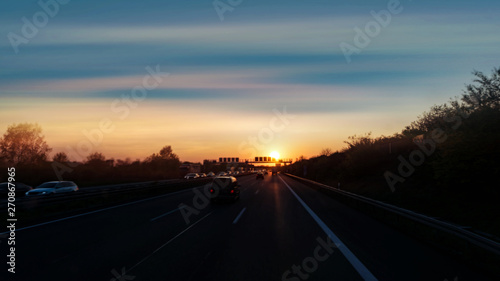 Sunset road . Cars and trucks at sunrise . Night highway .  © yaalan