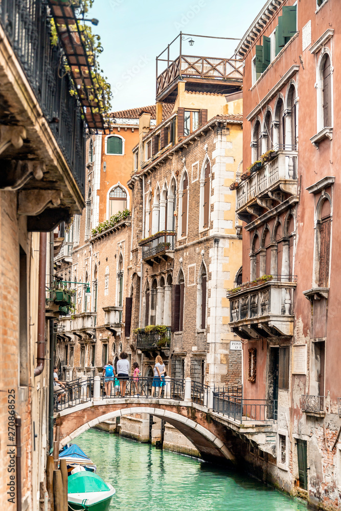 Old canal with boats and bridge in Venice, Italy. Street with old Italian architecture of Venice