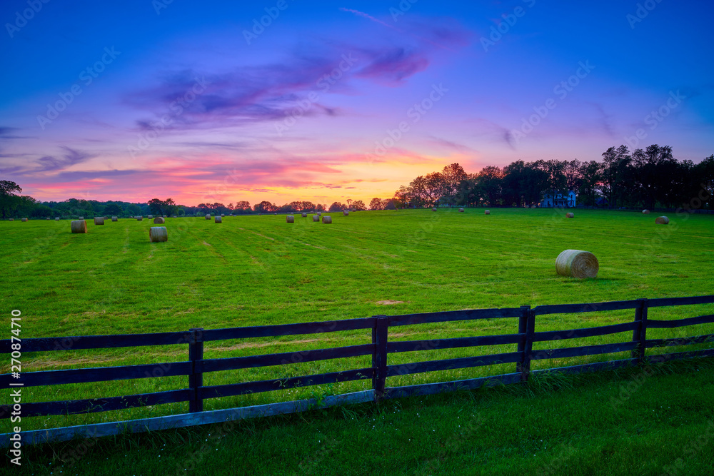 Round Hay Bails in a Field With Fence Round Hay Bails in a Field With Fence
