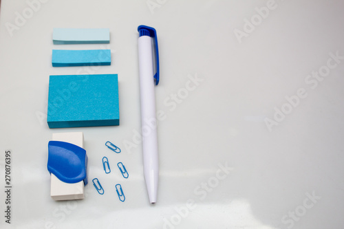 Materials on white table, pen, message blocks, paper clips, rubber and page markers