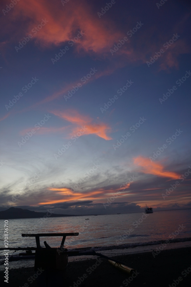 sunrise during summer on the beach with the foreground of a fishing boat