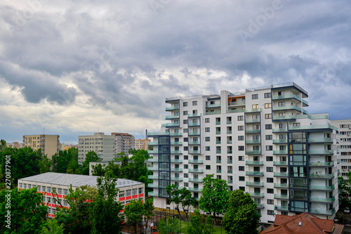 White, empty apartments building with stormy clouds above. Generic modern architecture in East Europe. For sale and rent concept.