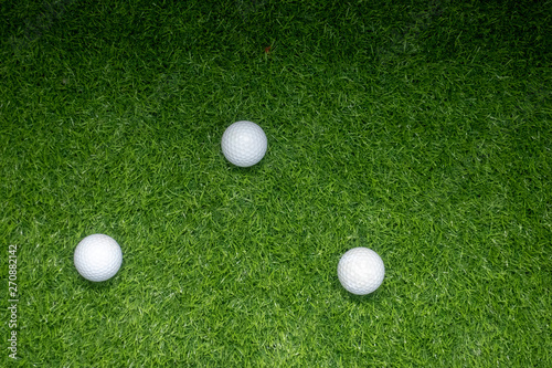 Golf balls are on green grass