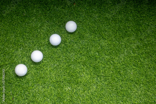 Golf balls are on green grass