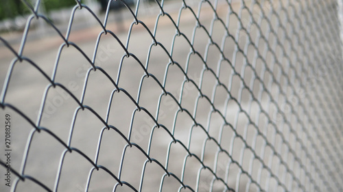 Close up the grid of a metal fence in Sports street park