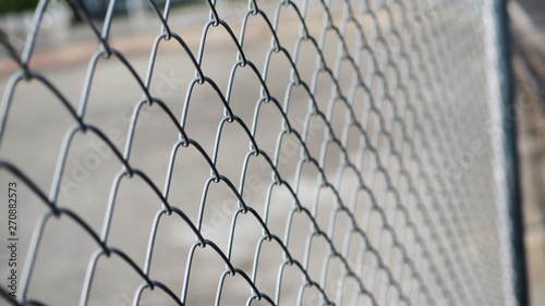 Close up the grid of a metal fence in Sports street park