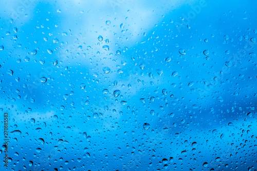 Drops of rain on blue glass background