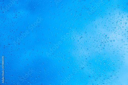 Drops of rain on blue glass background