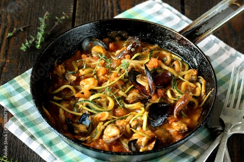 Zucchini (noodles) Zoodles Spaghetti With Mussels In Tomato Sauce In A Frying Pan. Keto Pasta Low-Carb  Spaghetti Tarantina. recipes for fatty protein foods  photo