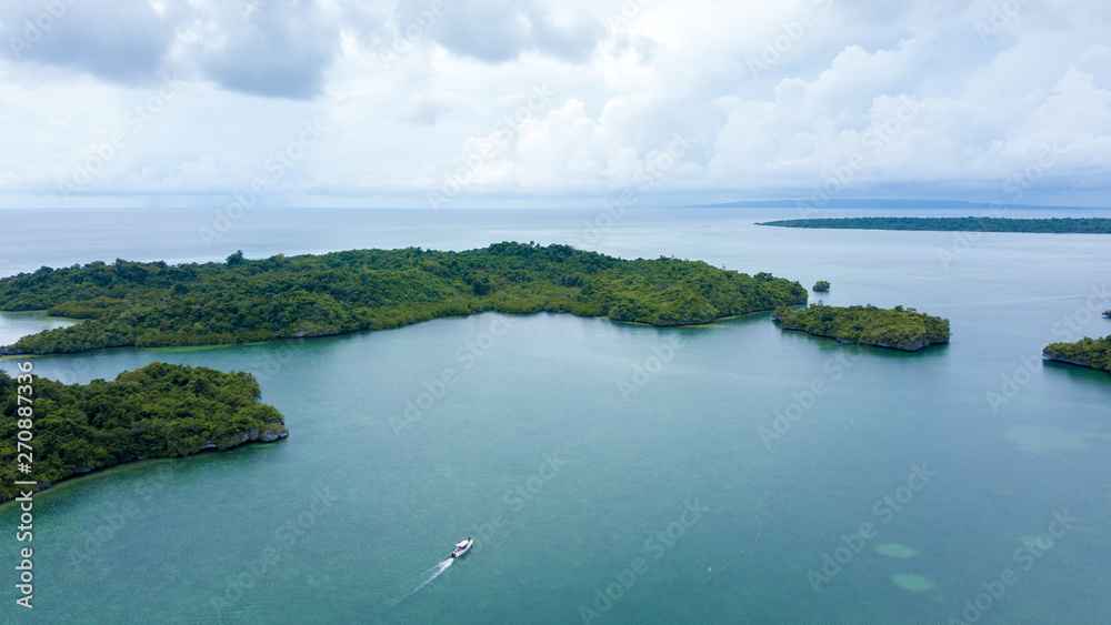 Aerial photography view of Wakatobi (Wangi-Wangi, Kaledupa, Tomia & Binongko) islands with a white boat, Southeast Sulawesi, Indonesia