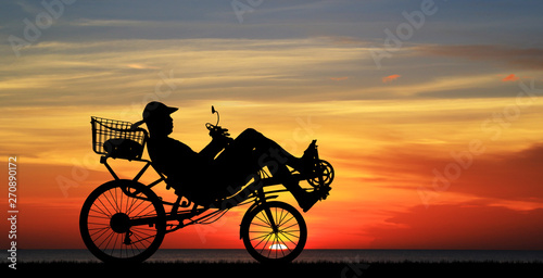 silhouette recumbent bicycle on sunrise  photo