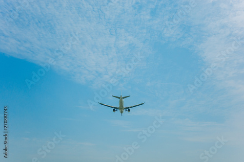 Fototapeta Naklejka Na Ścianę i Meble -  airplane flying over head against blue sky and clouds