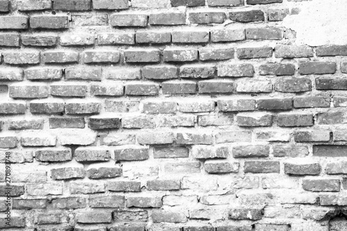 The old brick wall shows the arrangement of the aged bricks in black and white tones.