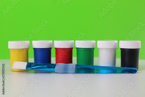 Set gouache paints for children isolated on a green and white background