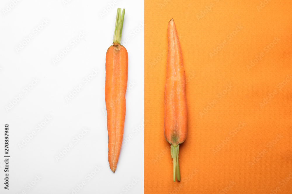 Flat lay composition with halves of fresh carrot on color background