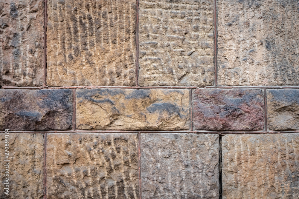 Stone wall texture: brown, orange, terracotta. Stone blocks seamless background. 