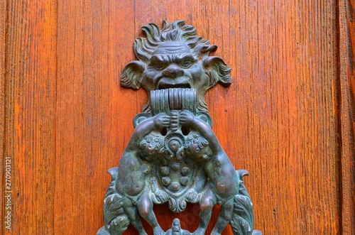 part of the door hammer in the form of faces and childhood figures