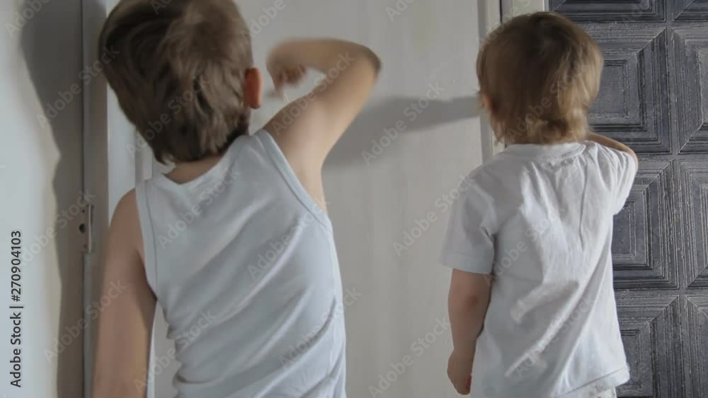 children brother and sister paint the wall with brushes and paint children brother and sister paint the wall with brushes and paint