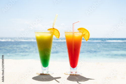 Red And Green Glasses Of Juice On The Beach
