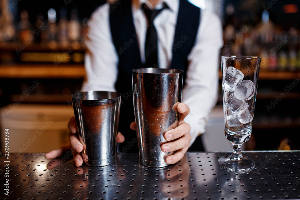 barman at work. A young bartender works with a shaker. Prepares delicious alcoholic cocktails