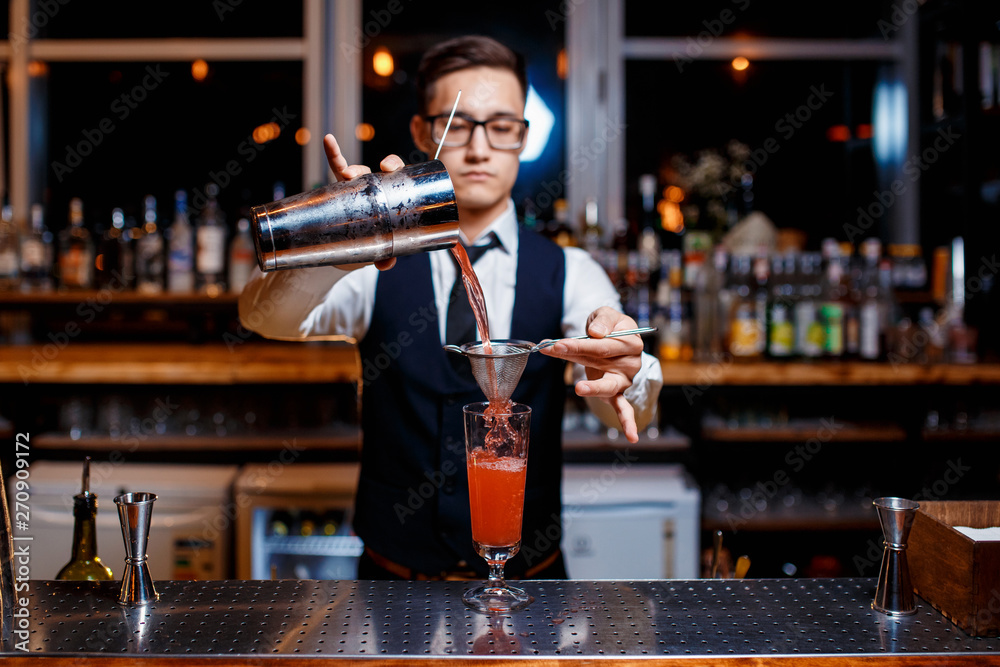The bartender prepares a delicious orange cocktail with citrus. bartender at work