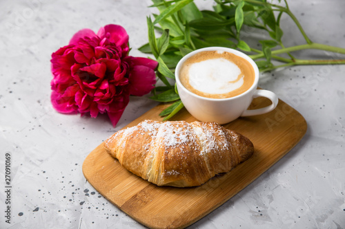 Fototapeta Naklejka Na Ścianę i Meble -  Beautiful and simple traditional French breakfast of fresh croissant and a cup of cappuccino