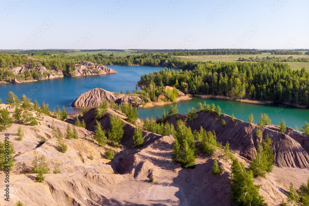 Aerial view of picturesque hills and blue lakes in Konduki, Tula region, Russia. Turquoise quarry in Romantsevo. Aerial view of picturesque hills and blue lakes in Konduki, Tula region, Russia. Turquoise quarry in Romantsevo.
