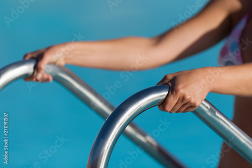 A woman hand holding a handrail in swimming pool