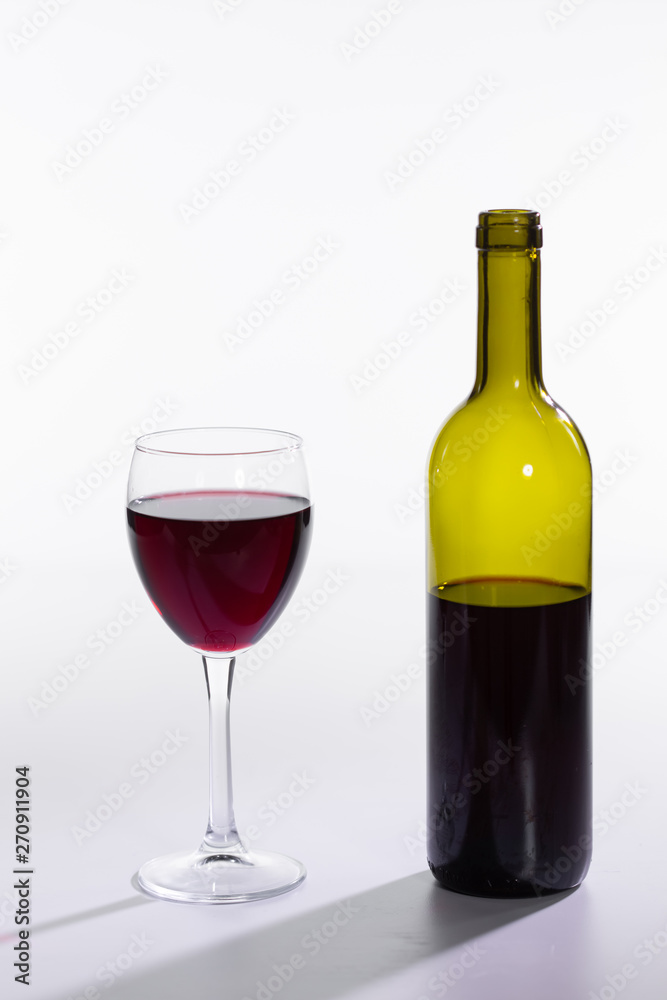 Glass and bottle with red wine on white background