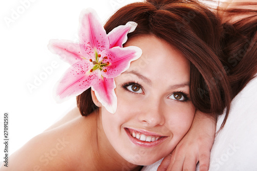 Girl with flower in hair on massge in spa salon isolated.