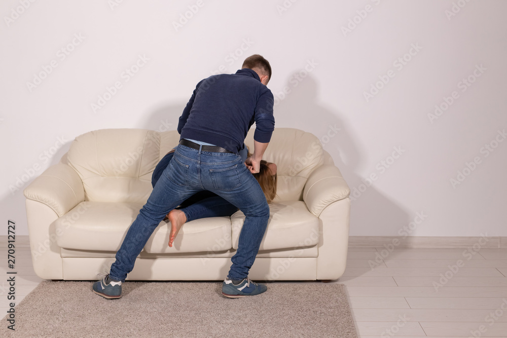 people, abuse and violence concept - aggressive man hitting his wife on sofa people, abuse and violence concept - aggressive man hitting his wife on sofa