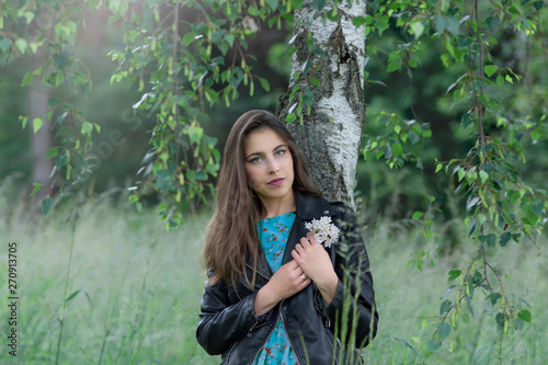 Portrait of a young woman in a birch grove