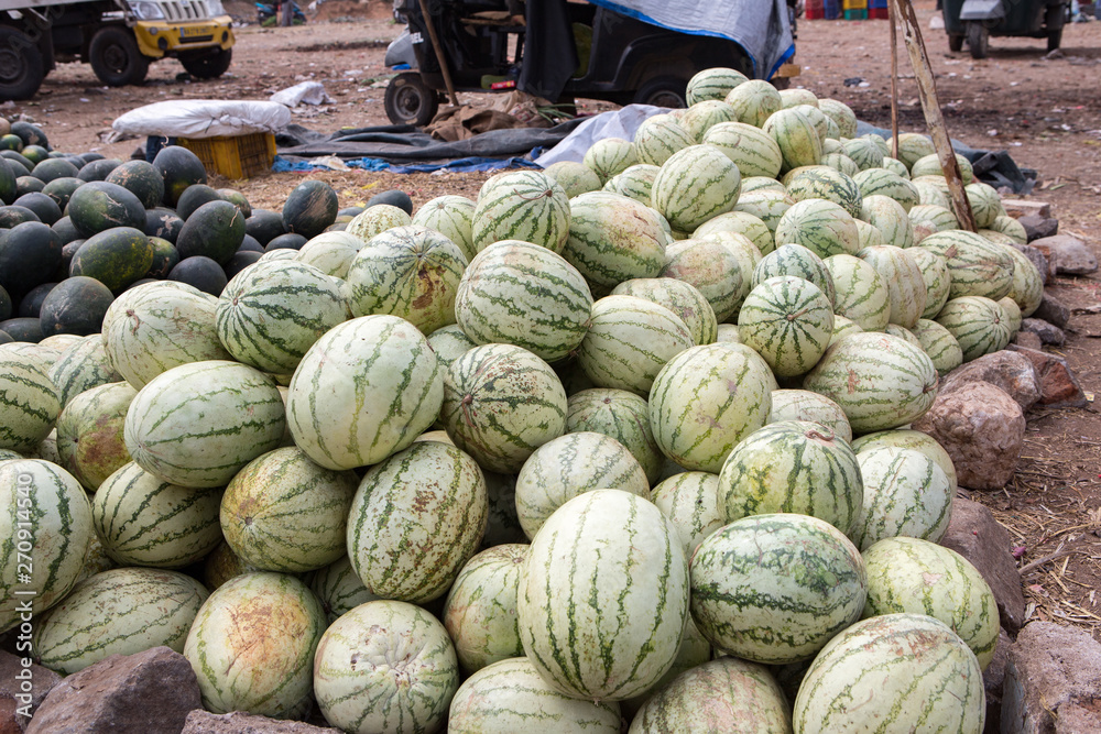 a messy pile of watermellons at an indian vegetable market in the south of india