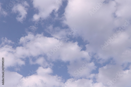 White clouds against the blue sky. Background, cropped shot, horizontal, place for text. Nature concept.