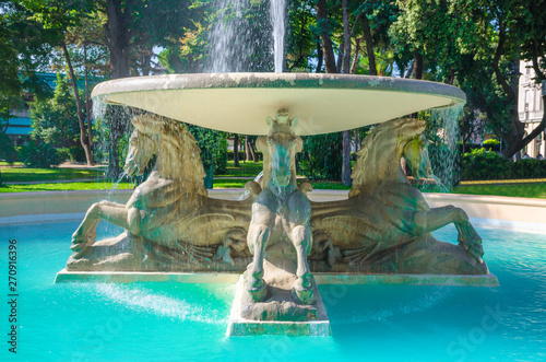 Quattro cavalli Four horses fountain with turquoise water in Parco Federico Fellini park with green trees in touristic city centre Rimini, Emilia-Romagna, Italy