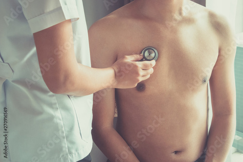 Doctor examining patient with stethoscope in hospital. Medical examination, stethoscope, medicine and therapy.