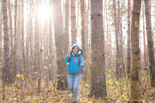 People, hike and nature concept - Woman dressed in blue jacket walking in the forest