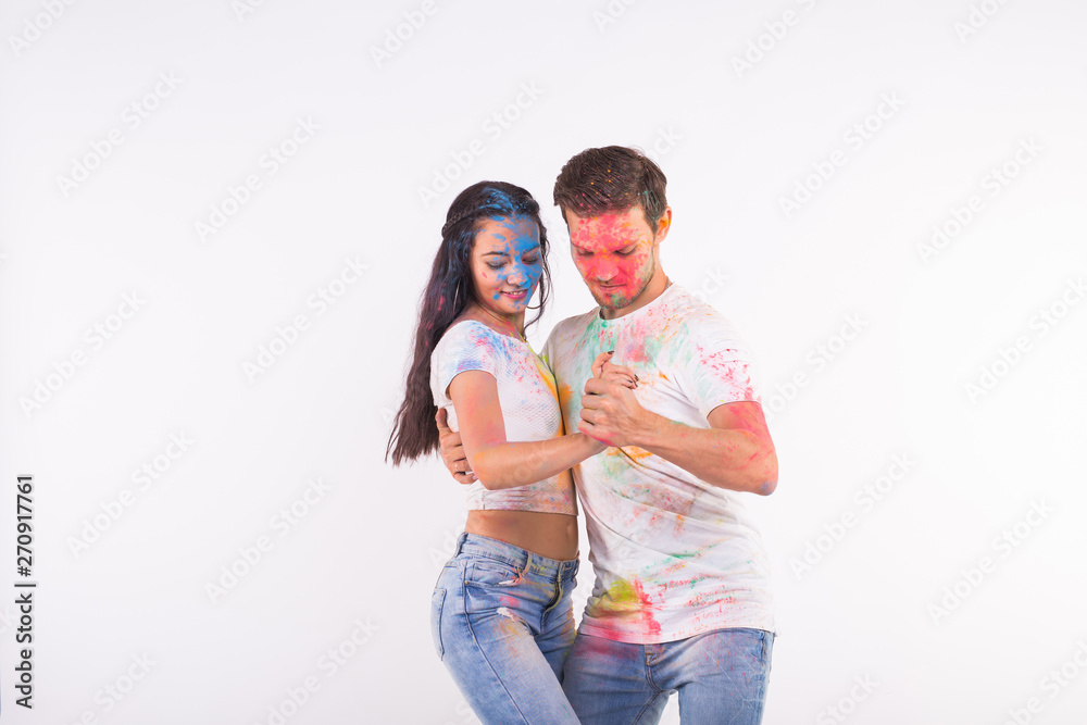 Festival of holi, social dance, friendship - young people playing with colors at the festival of holi and dancing bachata or kizomba on white background with copy space Festival of holi, social dance, friendship - young people playing with colors at the festival of holi and dancing bachata or kizomba on white background with copy space