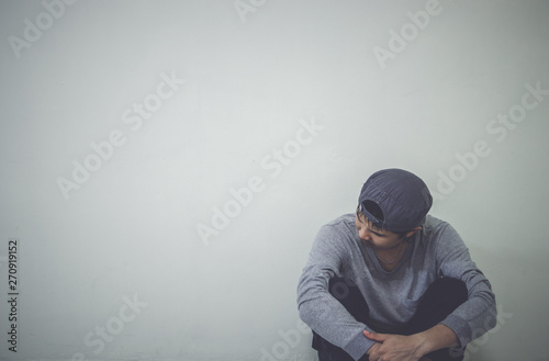 Depressed man sitting on floor in an empty room , This is major depressive disorder. photo
