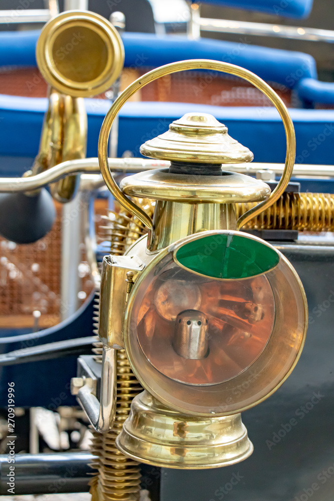 The headlight of the old car. Veteran car with large golden light, close up.