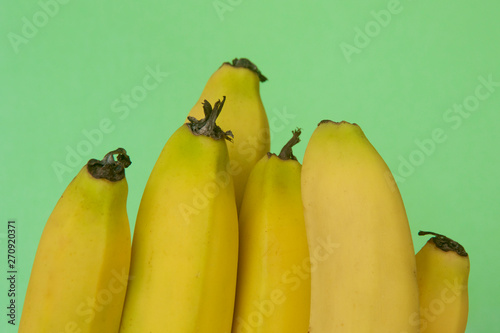 A bunch of ripe bananas on a green background.