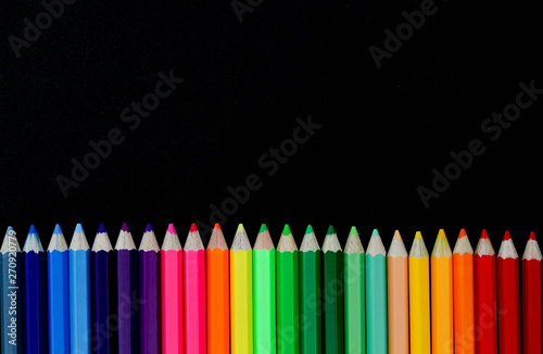 Multicolored Pencils on black background.