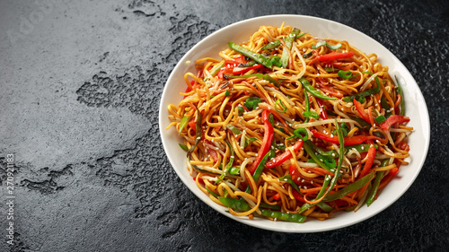 Chow mein, noodles and vegetables dish with wooden chopsticks photo