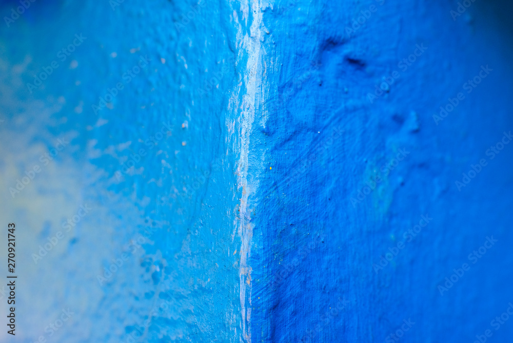 Abstract background of blue tones, with paint texture on a concrete wall.