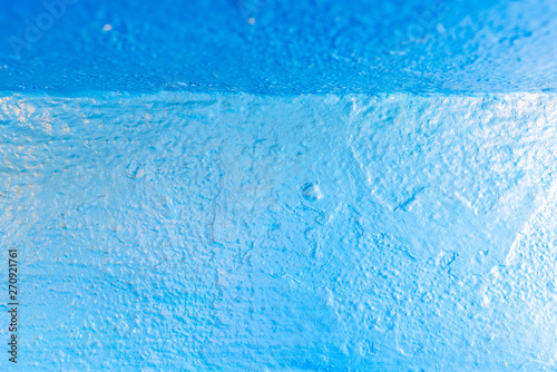 Abstract background of blue tones, with paint texture on a concrete wall.