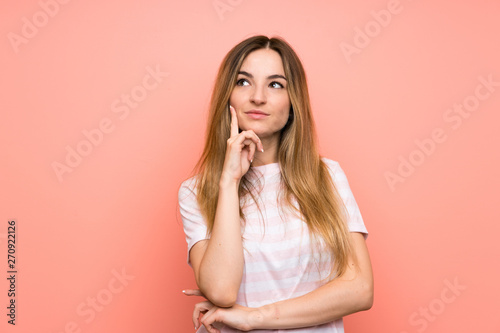 Young woman over isolated pink wall thinking an idea