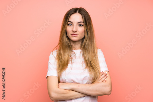 Young woman over isolated pink wall keeping arms crossed