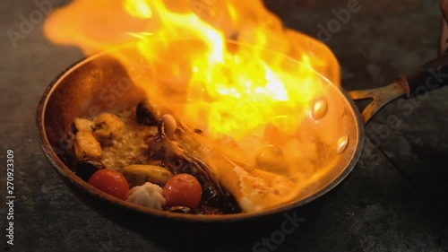 Seafood meal cooking. Mediterranian food recipe. Chef flambering skills. photo