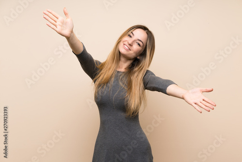 Young woman over isolated background presenting and inviting to come with hand