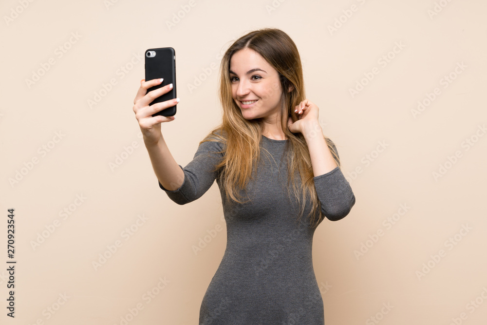 Young woman over isolated background making a selfie